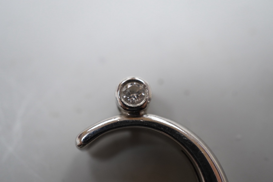 A diamond pendant, designed as a crescent moon accented with two collet-set brilliant-cut diamonds totalling approximately 0.20 carats, one sliding up and down the inner curve of the moon, length 2.6cm, mounted in platin